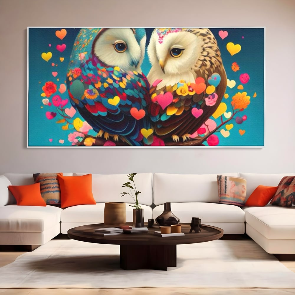 Tablou canvas cu tablou canvas cu doua bufnite colorate si inimi, in rama de aluminiu argintiu, pe perete intr-un living